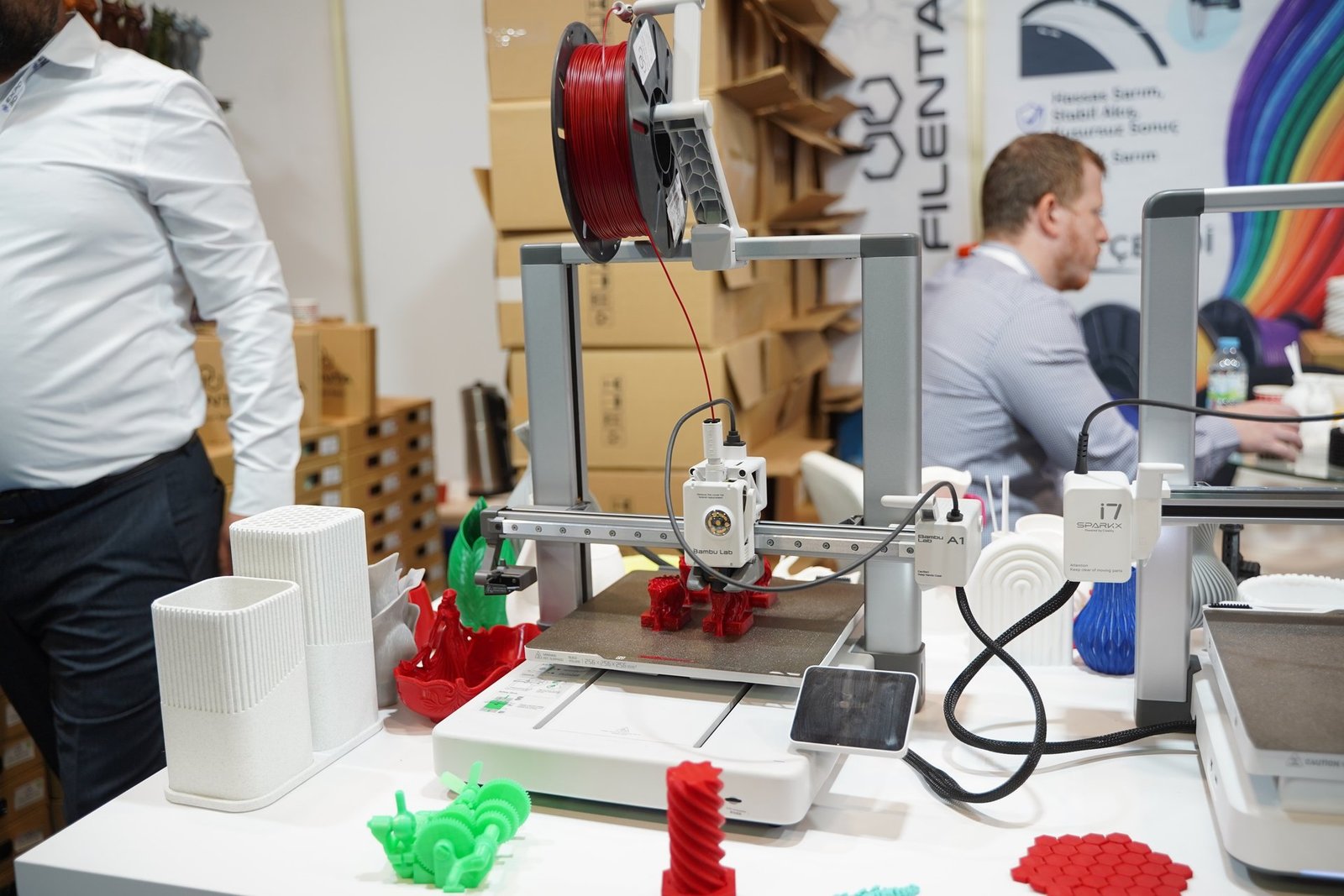 EXPO3D İstanbul'da bir standda çalışan masaüstü 3D yazıcı ve ürettiği parçalar