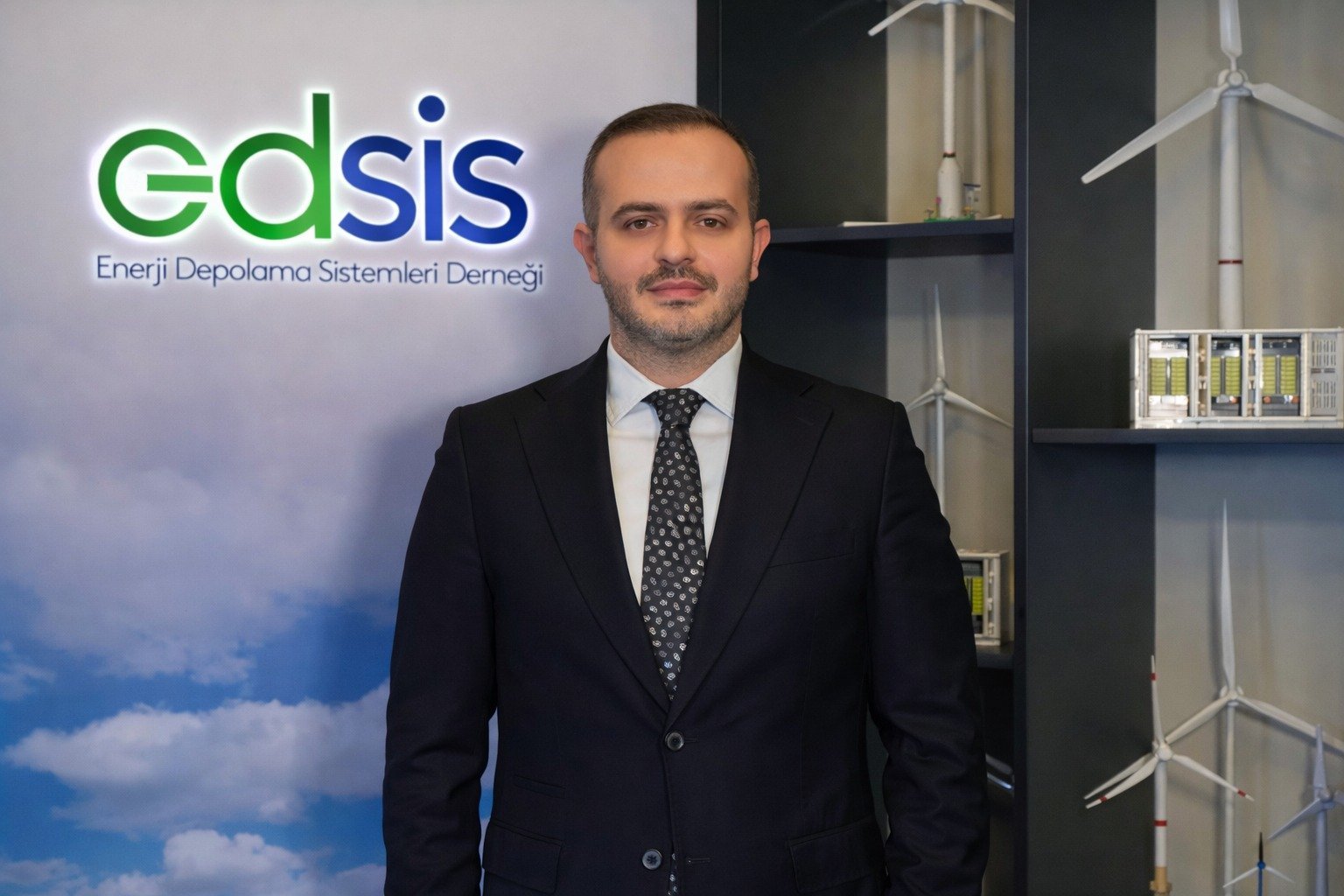 EDSİS Yönetim Kurulu Başkanı C. Can Tutaşı, dernek logosunun önünde