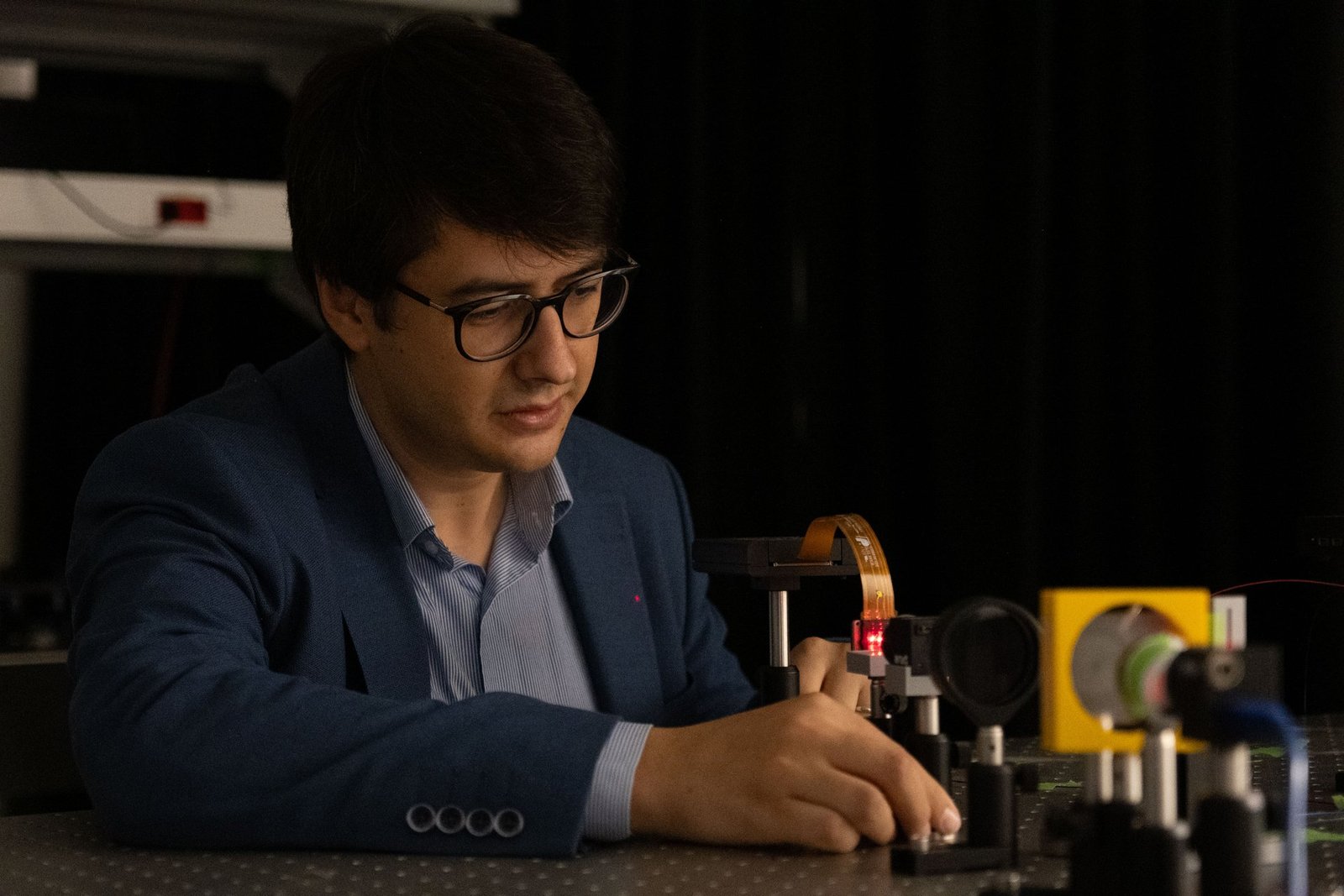 Koç Üniversitesi'nden Dr. Öğr. Üyesi Uğur Teğin laboratuvarda optik düzenek üzerinde çalışırken